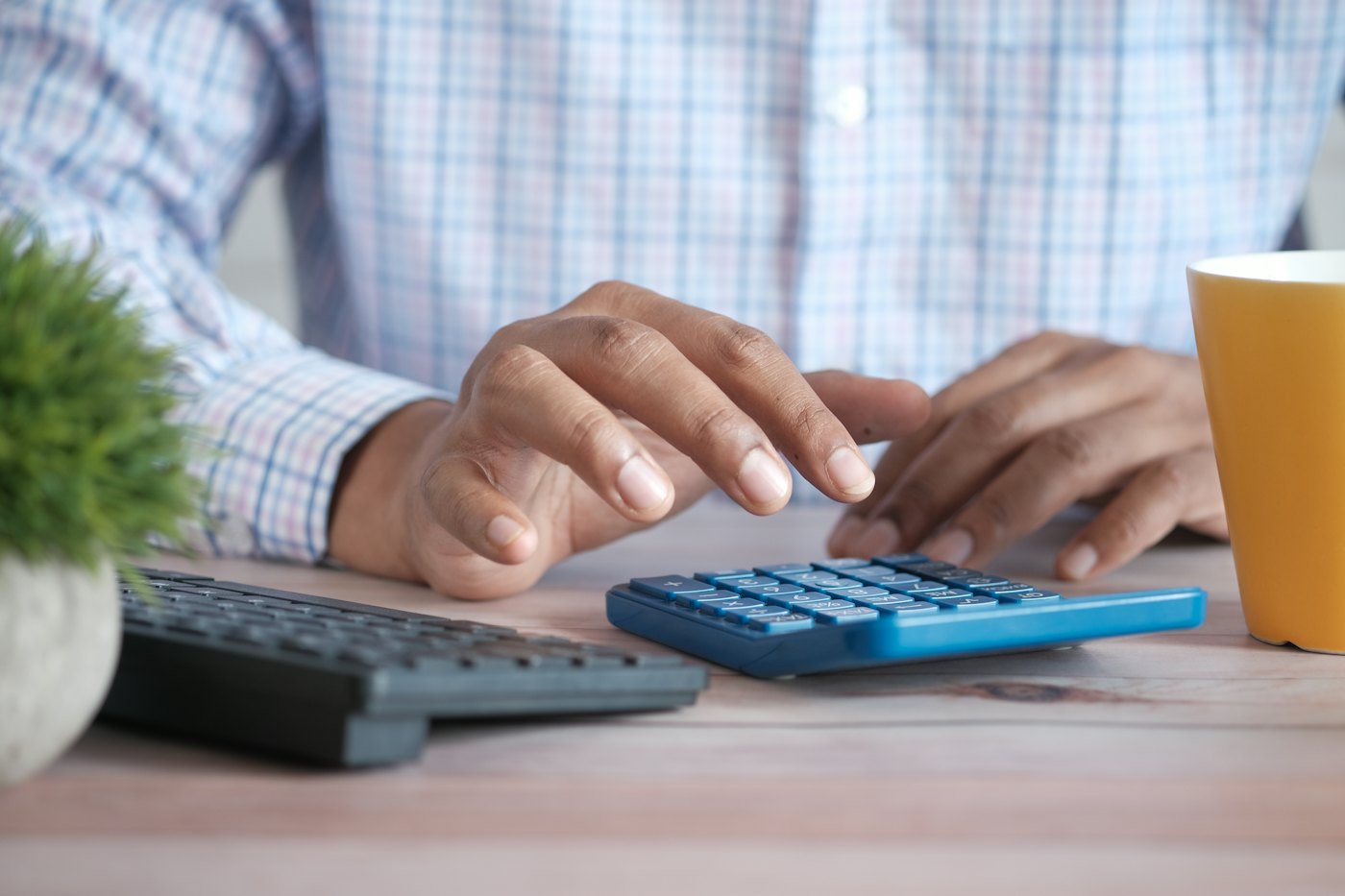 A person using a calculator at a desk to work out costs