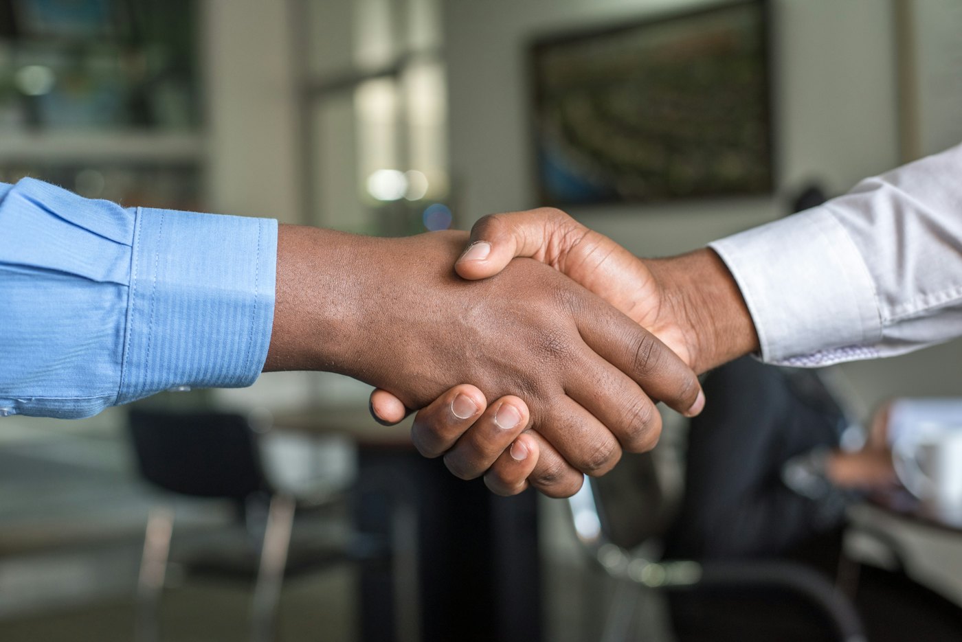 Two people shaking hands to close an agreement