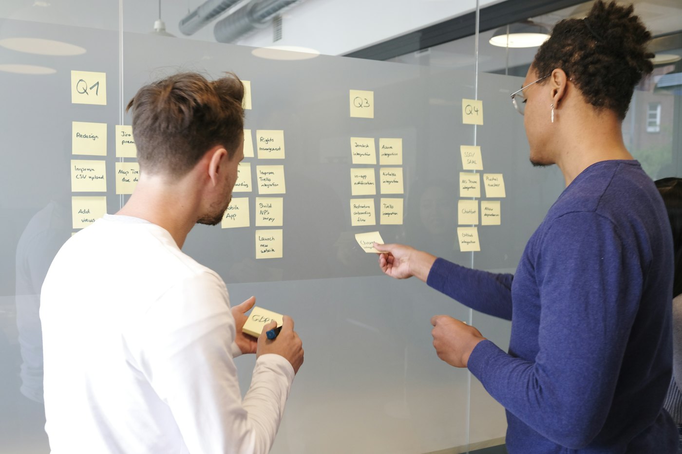 Two colleagues arranging a project plan on sticky notes